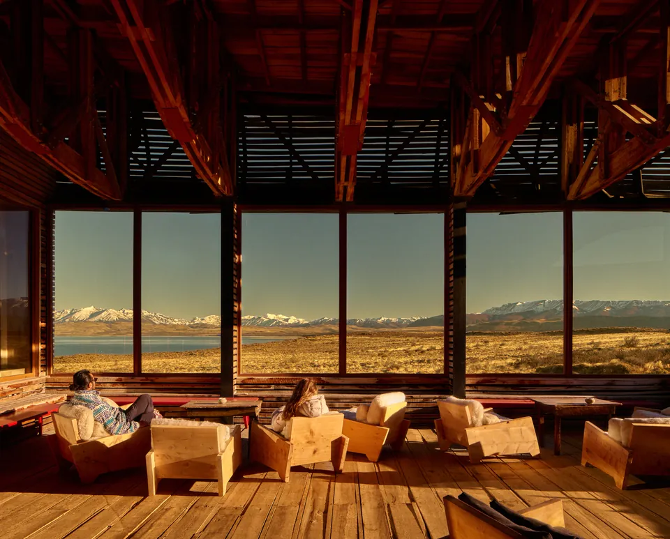 Lounge under timber beams, steppe and mountains through the windows