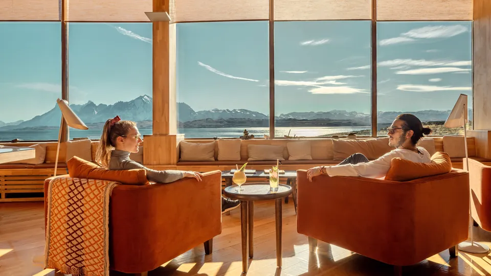 Two guests in a lounge with views to the mountains
