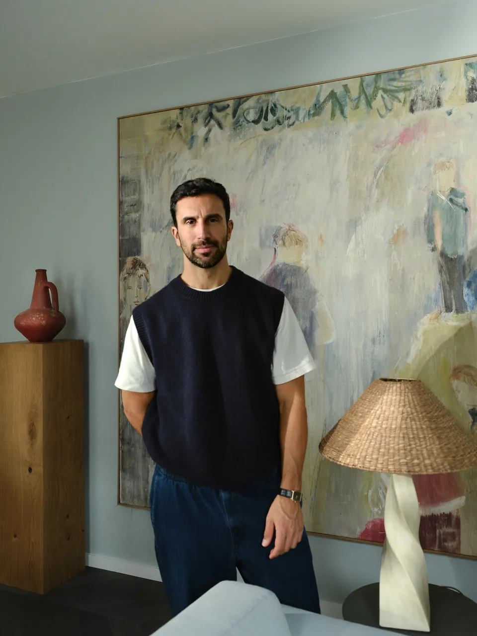 Portrait of the designer in front of a large painting