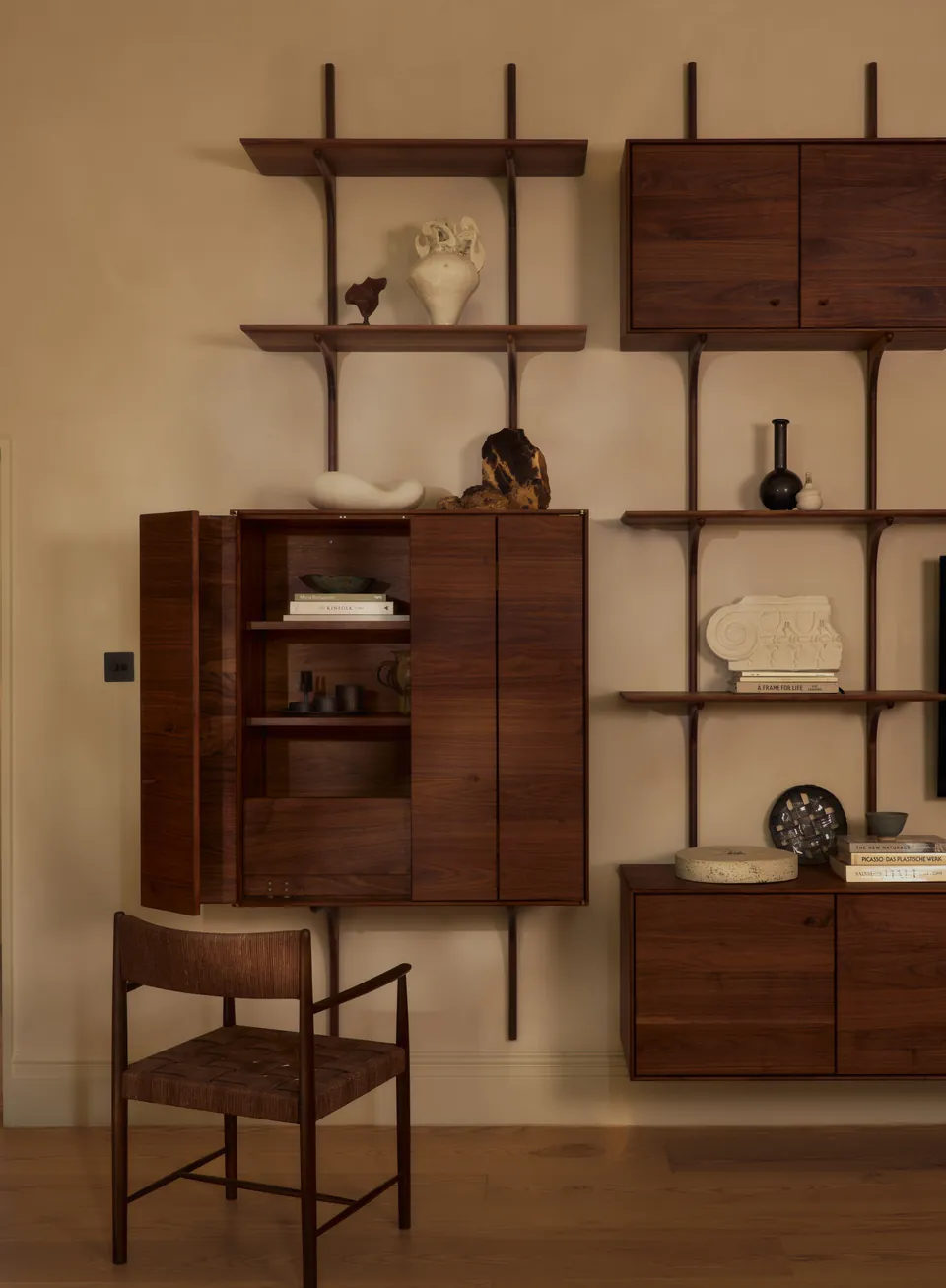 Walnut cabinet half open beside the shelves
