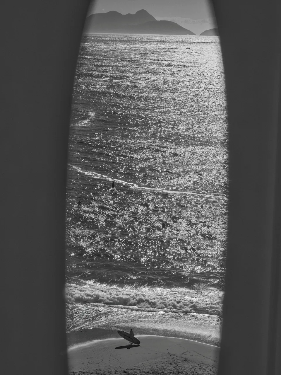 The sea and a distant headland through a narrow window, in black and white