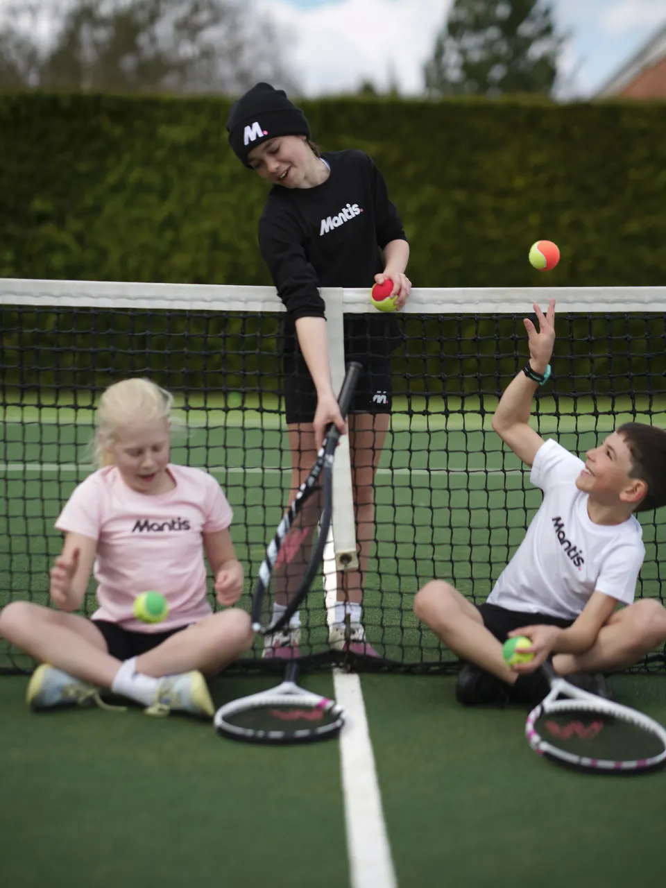Children at the net with rackets and balls