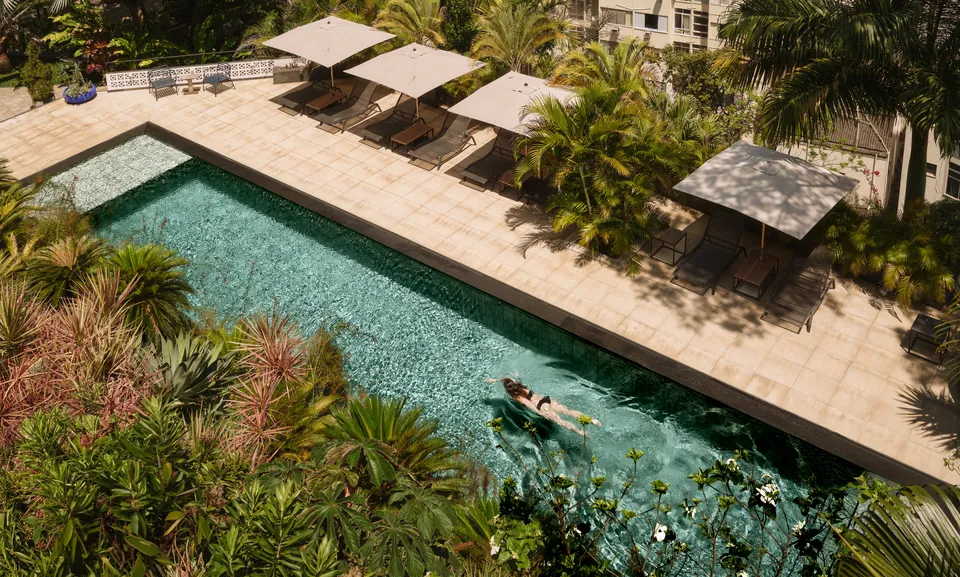 The pool from above, among palms and loungers