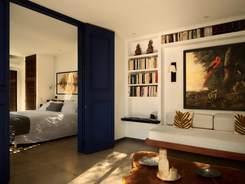 Blue doors open from the living room onto a bedroom