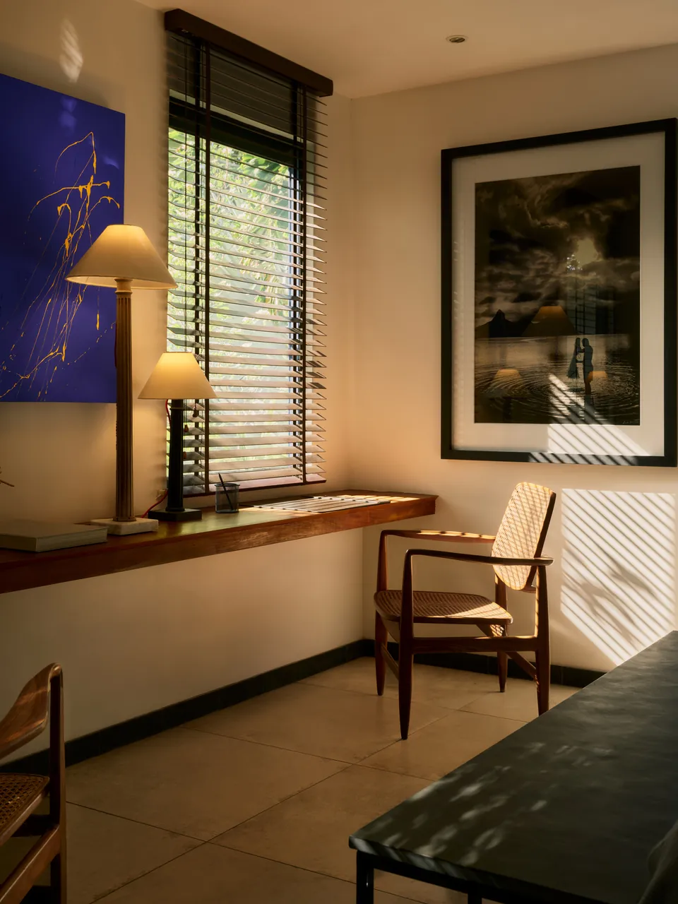 A study with a lamp, a chair and framed pictures