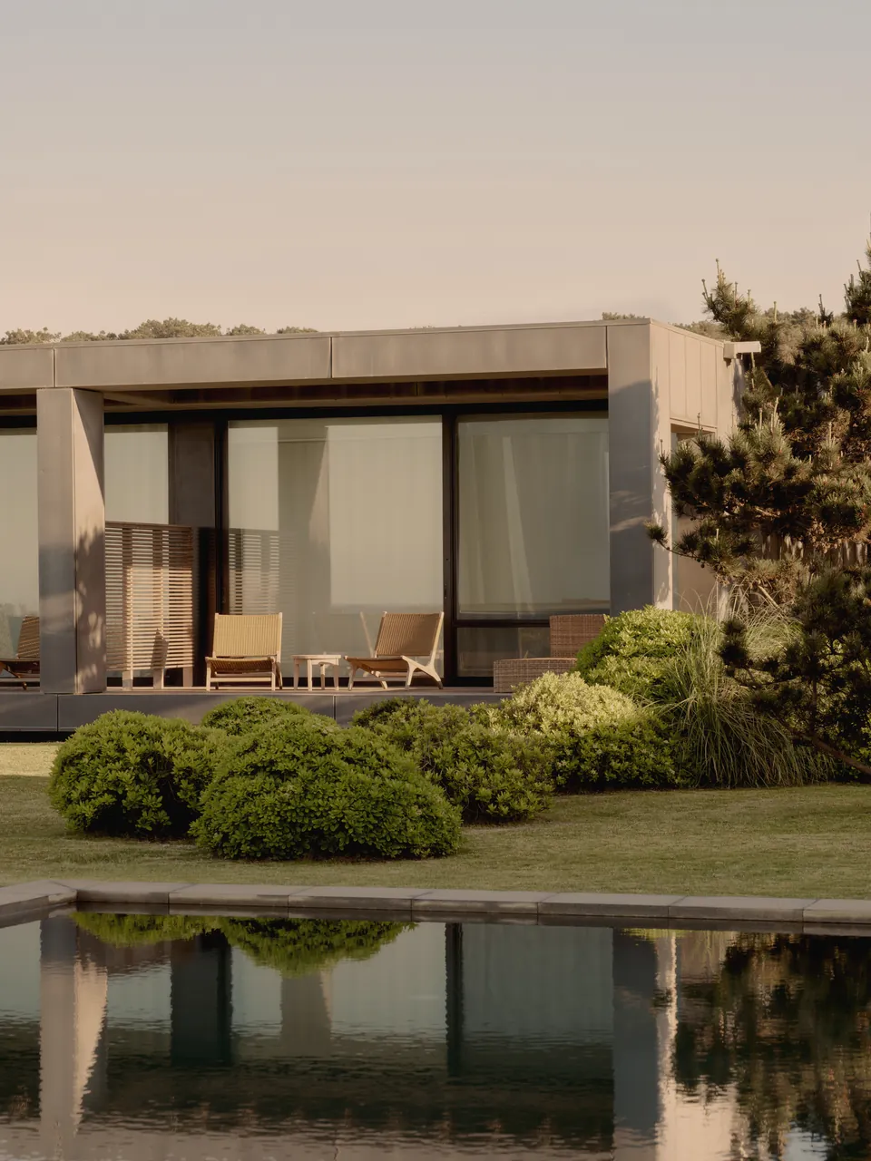 A pavilion with loungers beside a reflecting pool
