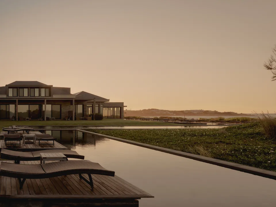 A long pool with loungers leading to the house