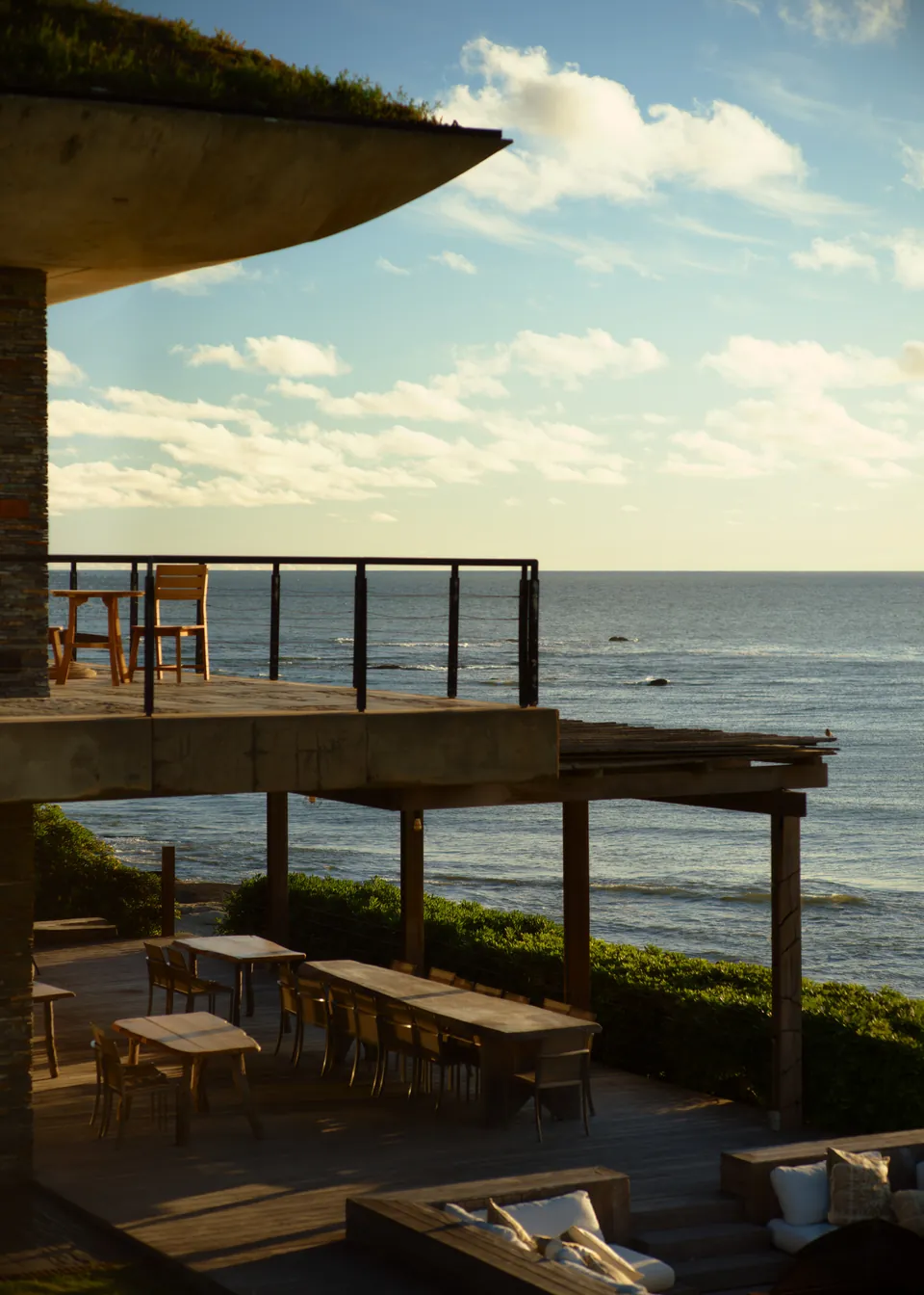 A terrace and deck above the sea at sunset